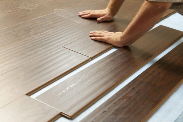 hardwood floor Man Installing New Laminate Wood Flooring Abstract.