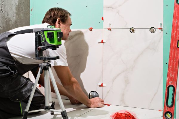 tiles floor Professional master man laying ceramic tiles on floor